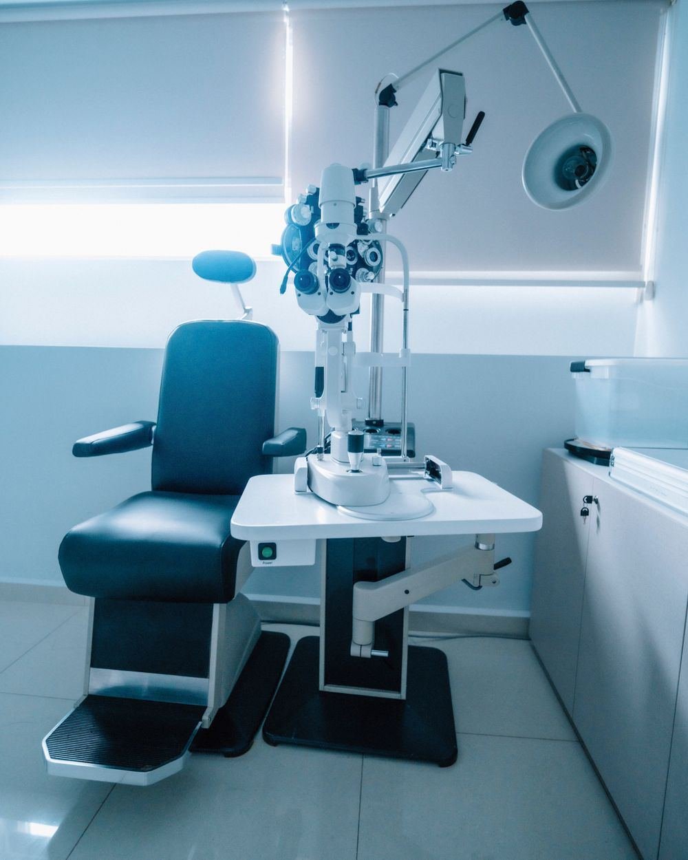 A modern optometry examination room with an ophthalmic chair and slit lamp