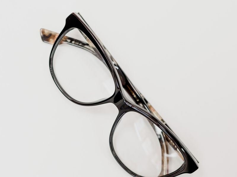 Prescription eyeglasses placed on a clean white table