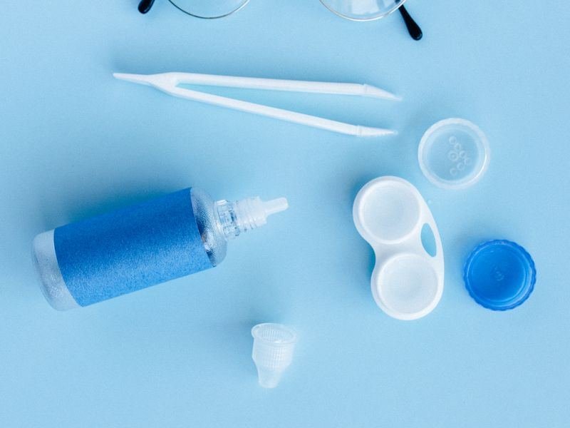 Eyewear essentials and accessories laid out on a blue surface